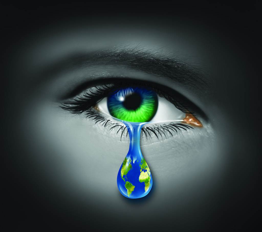 War and violence with the tear of a child and a planet earth in the reflection of the tear drop as a symbol of pain and world conflict on victims of crime or sadness on the state of the natural environment and polution.