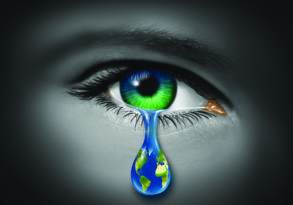 Close-up of an eye with a teardrop featuring the world, symbolizing environmental awareness and global concern.