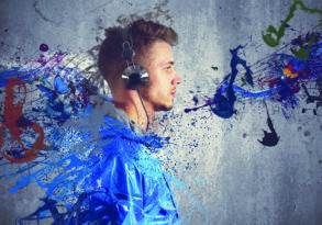 A young man in headphones surrounded by dynamic, colorful splashes of paint against a gray background, immersed in sound healing frequencies.