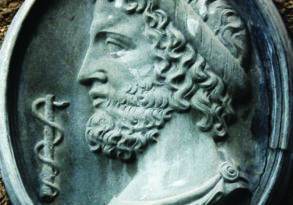 Oval bas-relief sculpture of a bearded man with curly hair and classic robe, featuring Greek inscription to the right related to dream interpretation.