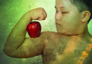 A young boy flexing his muscles and holding a red apple against his bicep on a textured green background titled "Dilemma in the Kitchen.