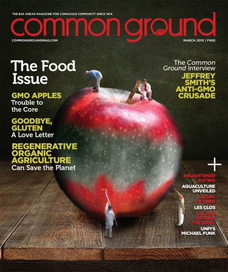 Magazine cover titled "Common Ground, March 2015" featuring a giant red apple with miniature people and birds on it, highlighting topics on GMOs and organic agriculture.