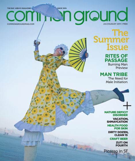 Cover of "Common Ground" magazine, August 2011, featuring a person in mid-air, dressed in a sunflower-patterned outfit, holding a parasol and a fan, with a fog