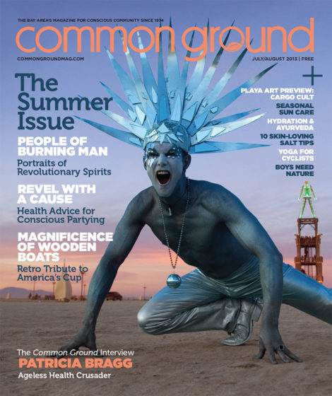 Magazine cover titled "common ground, July/August 2013" featuring a person with blue body paint and an elaborate headpiece, posing dramatically with industrial equipment in the background.