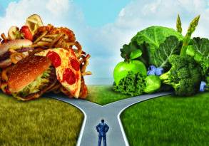 A man stands at a forked road; one path leads to a pile of junk food, the other to fresh fruits and vegetables, symbolizing a choice between unhealthy and deep nourishment.