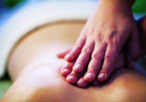 Close-up of hands performing a therapeutic massage on a person's back, emphasizing relaxation and therapy.