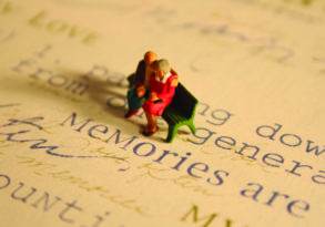 Miniature elderly couple sitting on a book, surrounded by text with the words "Tomorrow Versus Yesterday" visible.