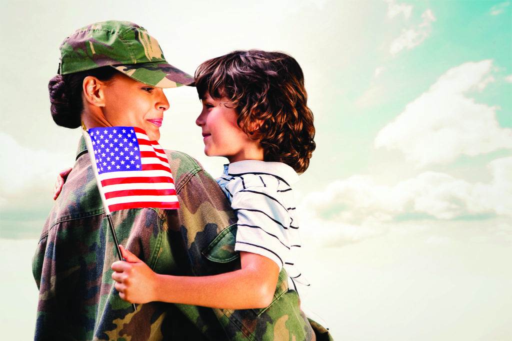 female soldier holding a boy who holds a flag