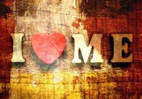 Text "I ♥ me" with a heart replacing 'love' on a textured, rustic wooden background symbolizing personal growth.