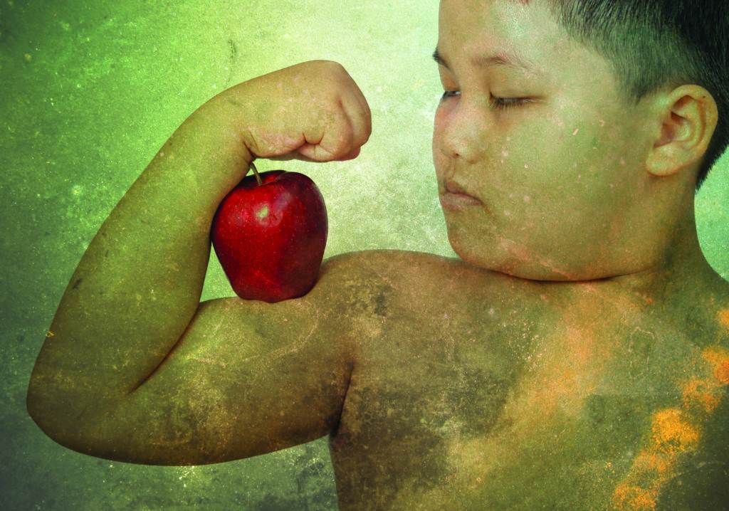 Fat boy flexes him muscle while showing off the apple that made her strong and healthy isolated