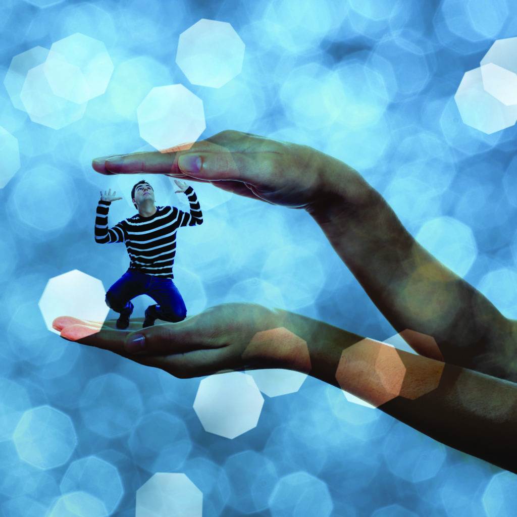 A picture of a young stressed man trapped in big hands over white background