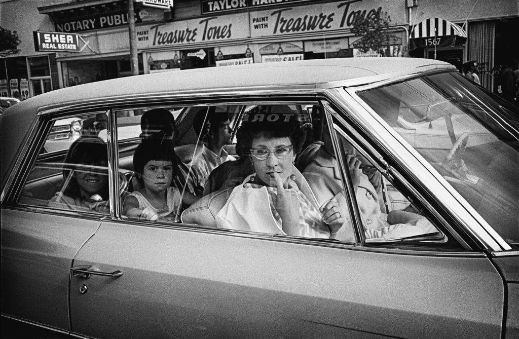 Tourists observe the Haight from their cars