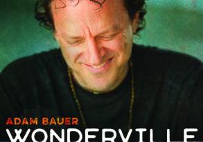 Album cover of "Wonderville" by Adam Bauer featuring a close-up of a smiling man with curly hair looking down.