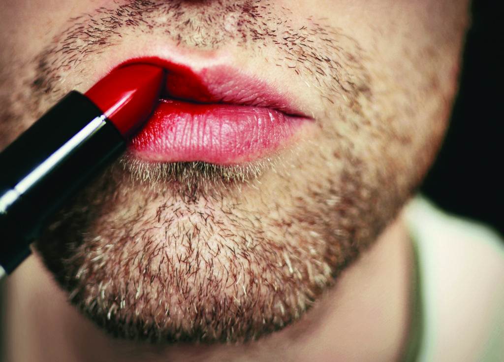 man paints lips