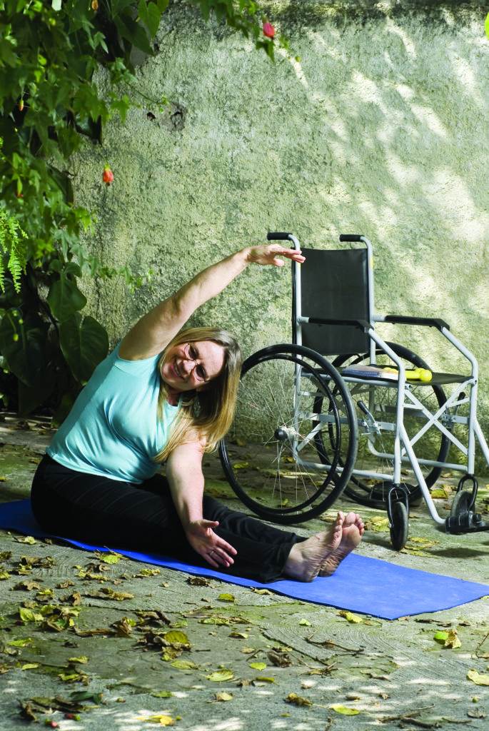 woman is doing yoga next to wheelchair