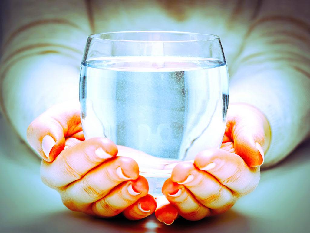 a glass of water on the palms