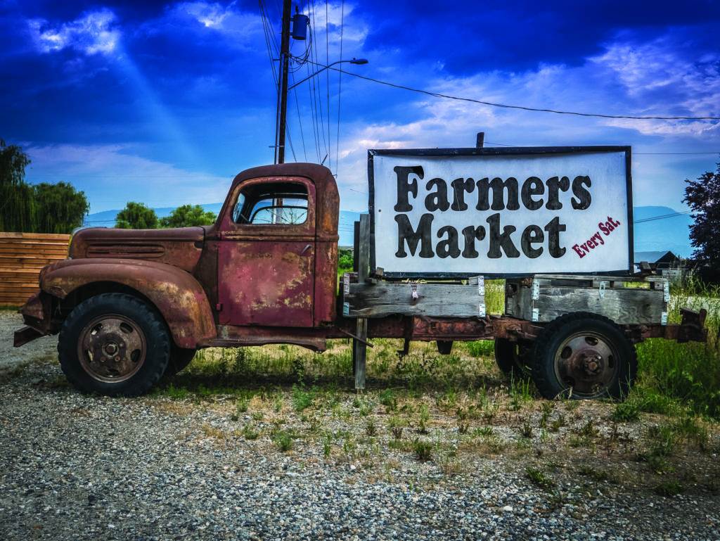 Sign For A Farmers Market On The Side Of A Vintage Rusty Truck