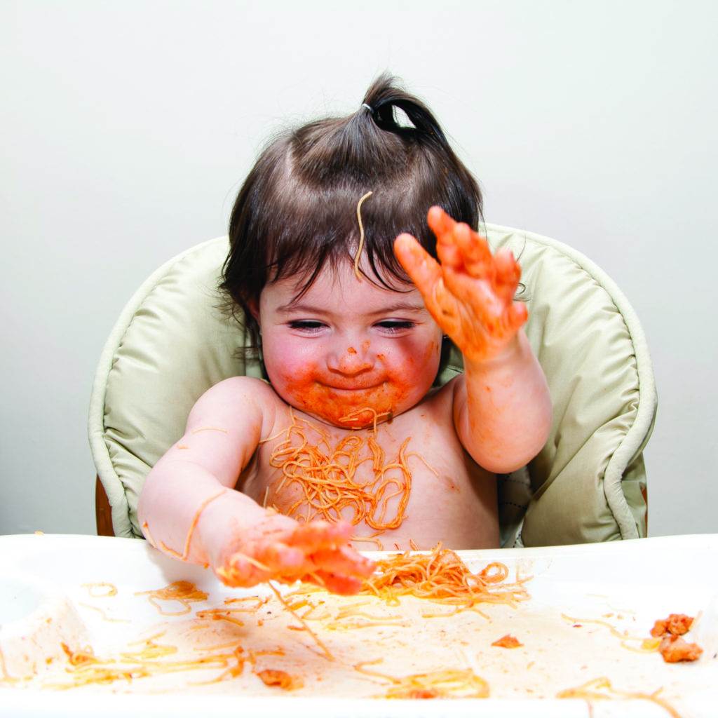 baby girl playing with spaghetti