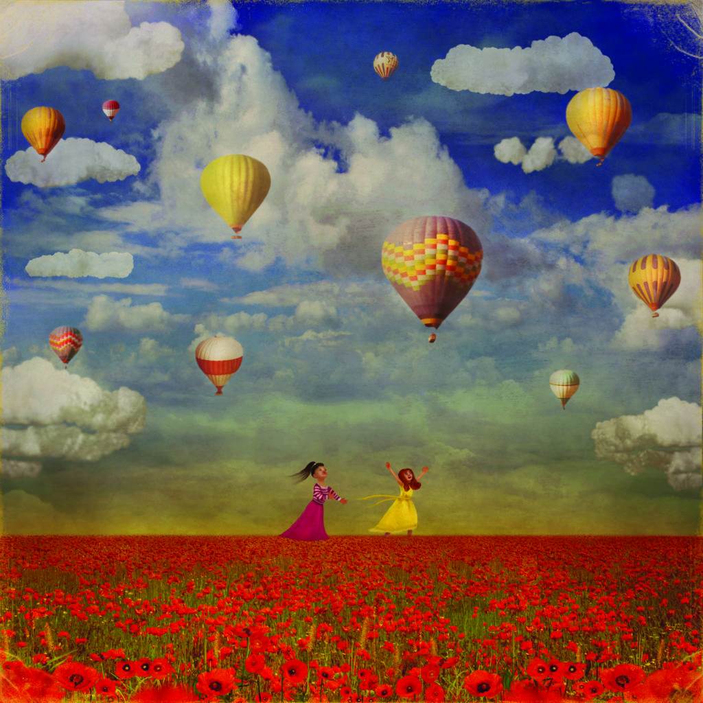 two girls running in a poppy field