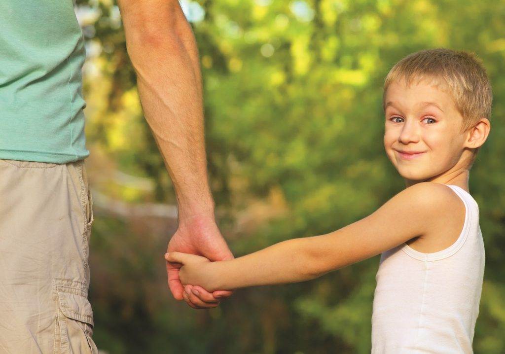 father holds his son by the hand